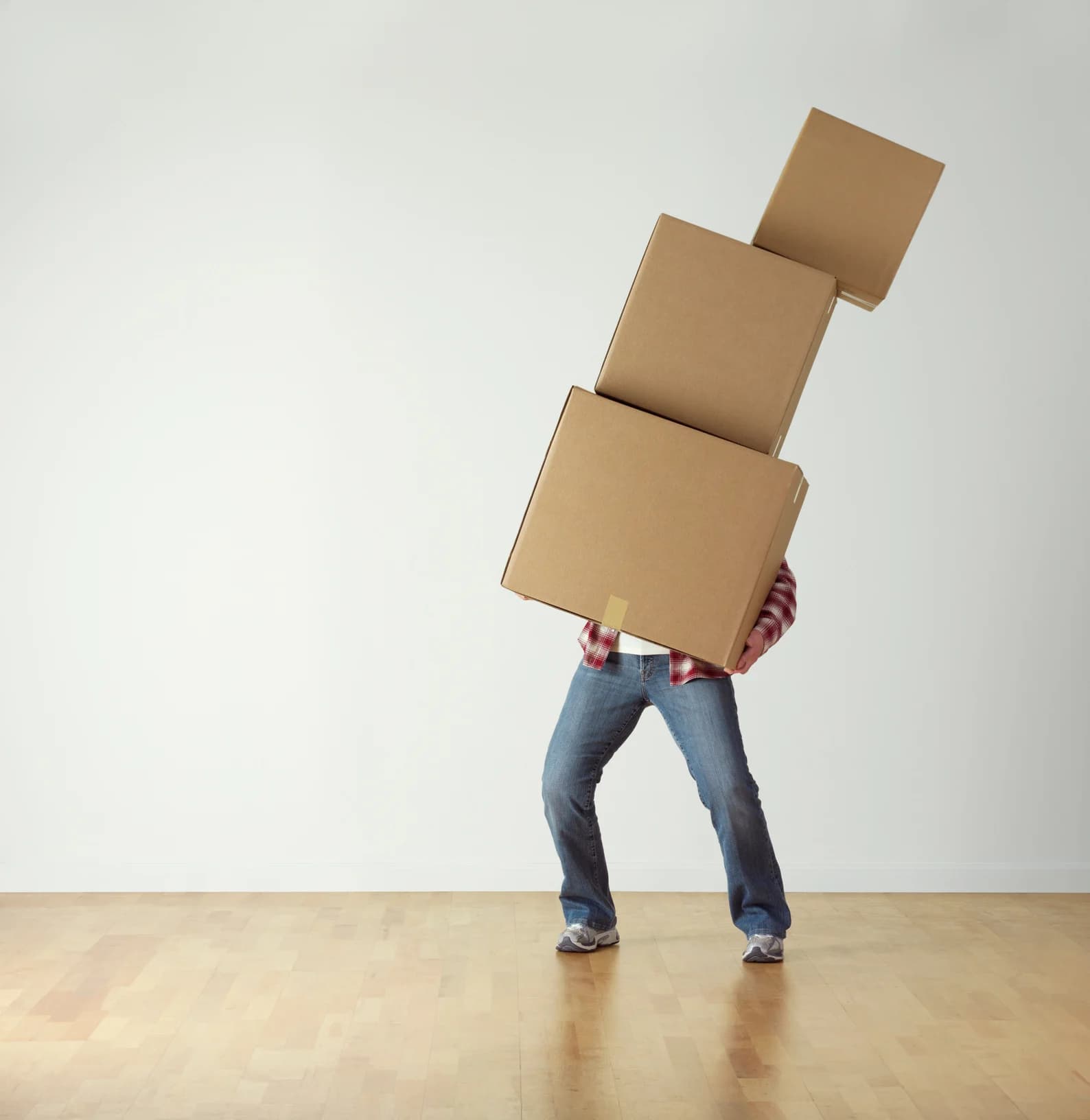 Person carrying stacked cardboard boxes for packing and moving services in Salt Lake City